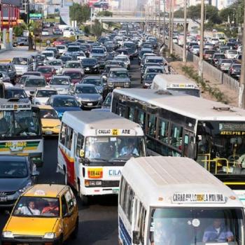 Foto de buses de transporte de lima y callao. Se muestra a los buses enfrentrandose para poder avanzar en una via congestionada