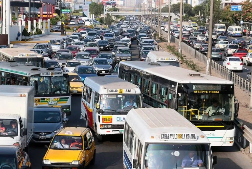 Foto de buses de transporte de lima y callao. Se muestra a los buses enfrentrandose para poder avanzar en una via congestionada